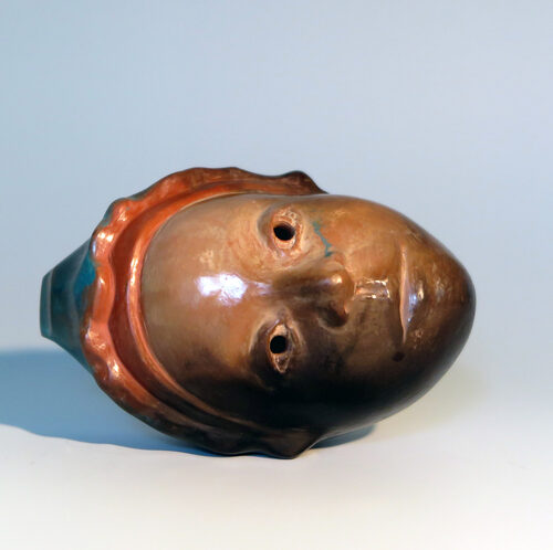 Ocarina in the form of a face with a cap